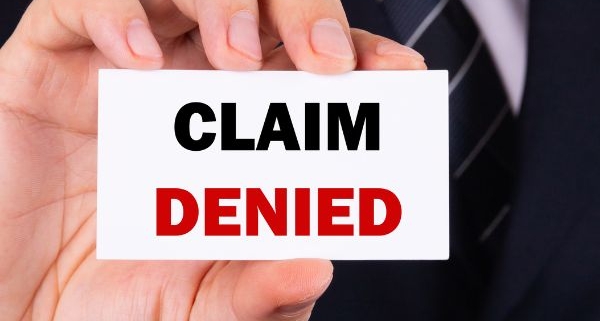 Man holding claim denied sign