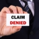 Man holding claim denied sign